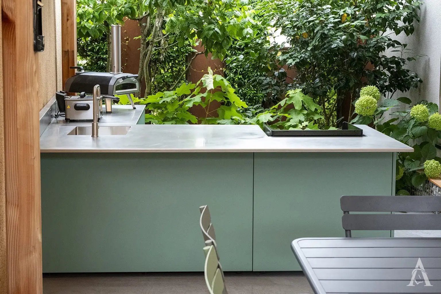 Cuisine extérieure haut de gamme dans un jardin contemporain en Valais